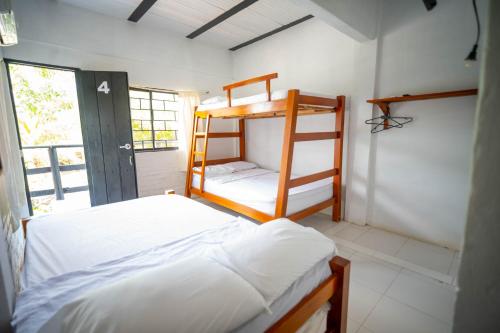 a bedroom with two bunk beds and a window at Cabaña la Arenosa in Coveñas