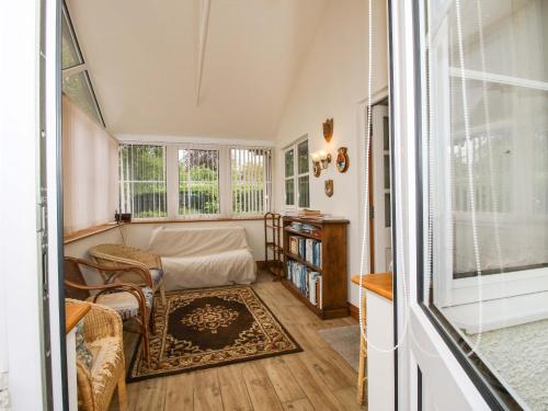 a living room with a bed and a window at Willow Cottage in North Lydbury