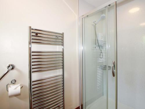 a shower with a glass door in a bathroom at Willow Cottage in North Lydbury