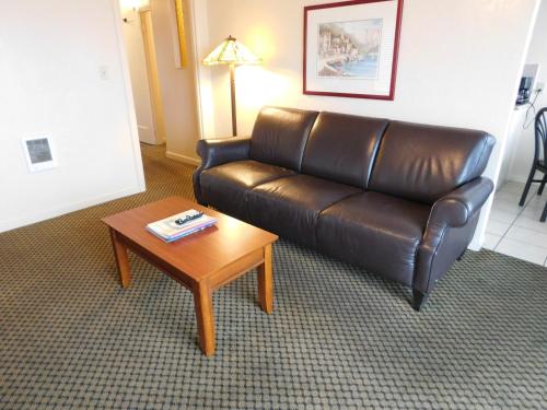 a living room with a leather couch and a coffee table at Capitola Venetian Vacation Rentals in Capitola