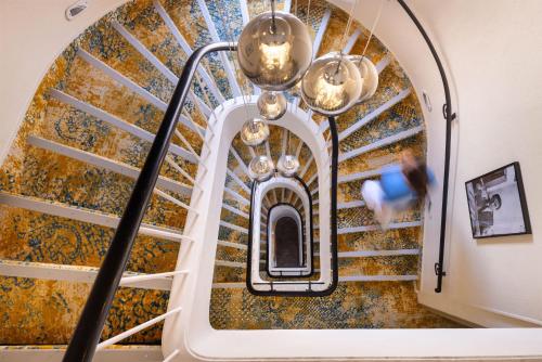 a spiral staircase in a building with a person taking a picture at Best Western Hôtel des Orangers Cannes in Cannes