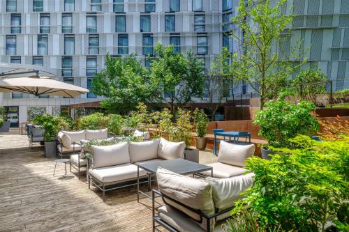 a patio with chairs and tables and a building at Radisson Blu CDG Airport Terminal Hotel, Paris in Tremblay-En-France