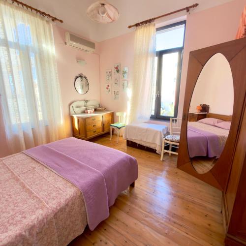 a bedroom with two beds and a mirror at Marys Central Beachside Mansion in Agios Nikolaos