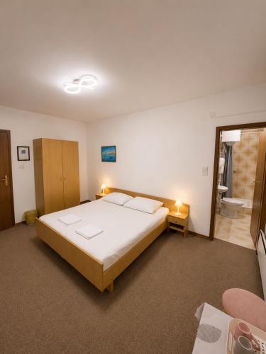 a bedroom with a large bed and a bathroom at Rooms Nada in Senj