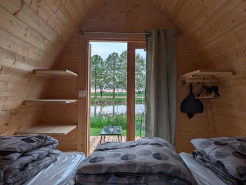 a bedroom with two beds in a wooden cabin at Camping de Graçay in Graçay