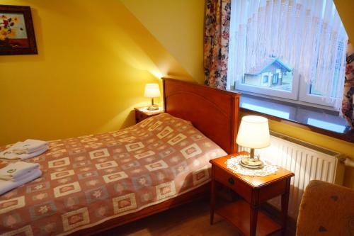 a small bedroom with a bed and a window at Majątek Giże Marczak in Olecko