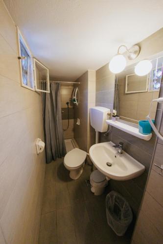 a small bathroom with a toilet and a sink at Anna Christina in Kamena Vourla