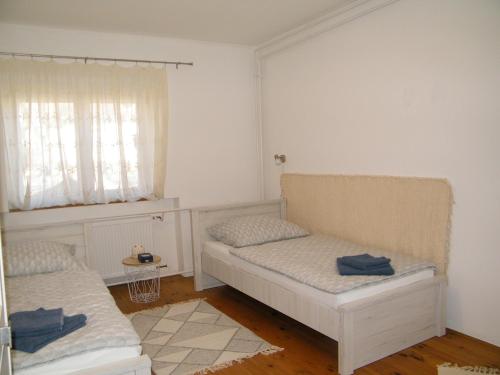 a bedroom with two beds and a window at Sártekerő Vendégház in Alsópáhok