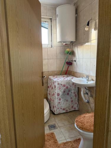a bathroom with a toilet and a sink at Ring Urban Apartment in Kosovo Polje