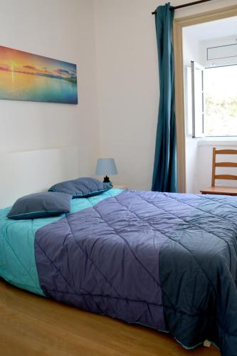 a bed with a blue comforter in a bedroom at Recanto do Capucho in Conceição