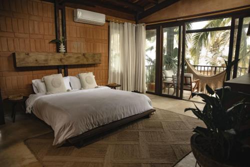 a bedroom with a bed and a large window at Costeño Beach in Santa Marta