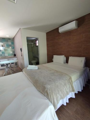 a bedroom with two beds and a desk in it at Villas Supreme Apartamentos in Maceió