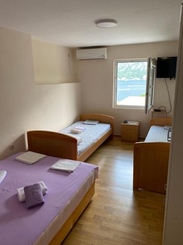 a room with two beds and a window at Vila Ruška in Prčanj