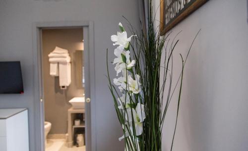 a vase filled with white flowers in a bathroom at Corso Experience in Rome