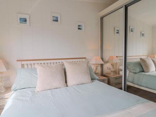 a bedroom with a bed with white sheets and pillows at Hazelwood 3 in Lyme Regis