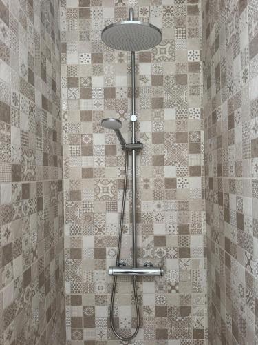 a shower with a shower head in a bathroom at The Nook, Lourinha in Lourinhã