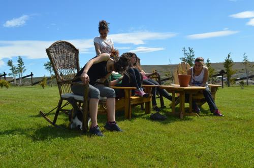 a group of people sitting around a table in the grass at Cabañas Teuepen in El Calafate