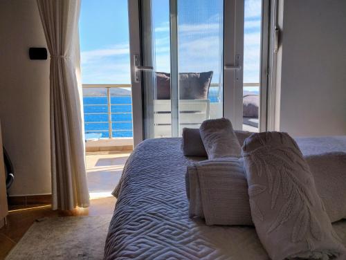 a bedroom with a bed with a view of the ocean at Βeachfront Luxury Apartments SARANDE in Sarandë