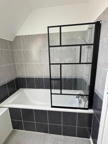 a bath tub with a window in a bathroom at Résidence de la Presqu'île in Plougonvelin