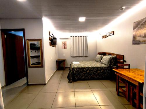 a room with a bed and a table in it at Fox pousada das águas in Prudentópolis