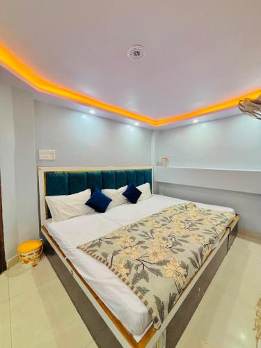 a bedroom with a large bed with blue pillows at Shri Homestay 800m from kashi vishwanath in Varanasi