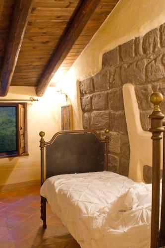 a bedroom with a bed in front of a stone wall at La Corte di Maria in Piccilli
