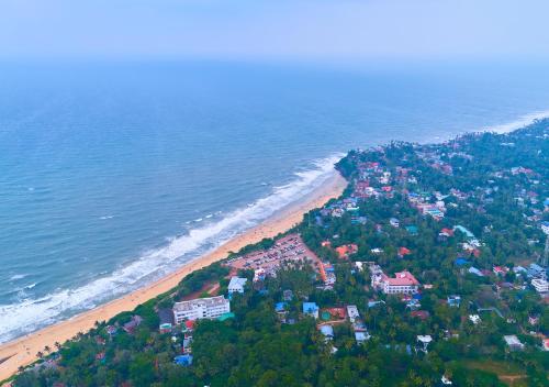 an aerial view of a beach and the ocean at De Waves Varkala by VOYE HOMES - Just 1 Km from Varkala Cliff and Beach in Varkala