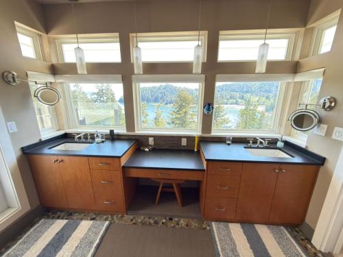 a large bathroom with two sinks and two windows at Bowen Island Ocean Retreat in Bowen Island