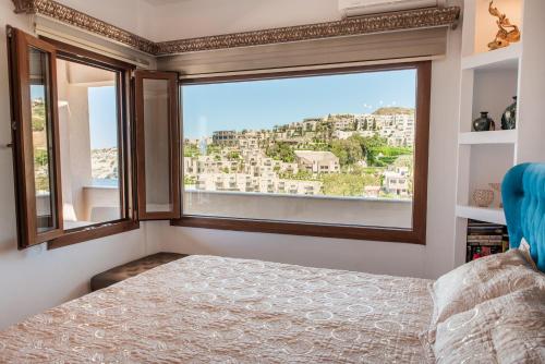 a bedroom with a window with a view of a city at Sea Front Panorama Villa Private Pool in Agia Pelagia