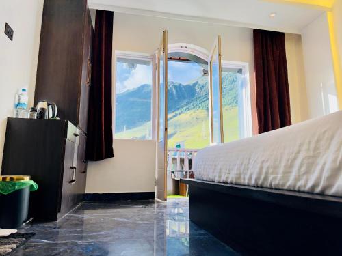 a bedroom with a bed and a large window at Arkay Sonamarg in Sonāmarg