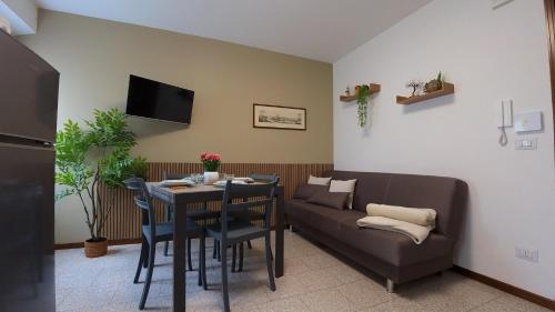 a living room with a table and a couch at Appartamento Squarà - con Vista Cascata, vicino Verona in Montorio Veronese