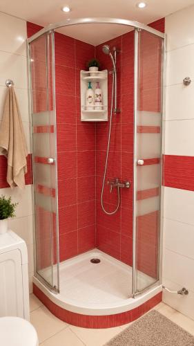 a bathroom with a shower with red tiles at Salou Beach Apartment with private Pool in Salou