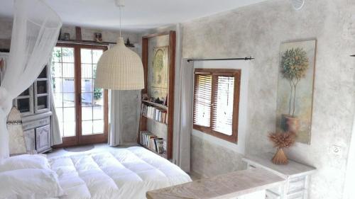 a bedroom with a large white bed and a window at maison florentine in La Gaude