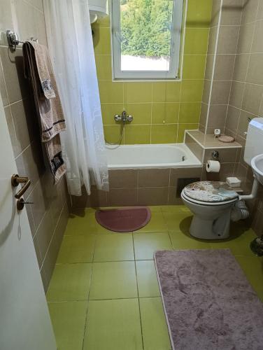 a bathroom with a tub and a toilet and a sink at Apartman Angela in Foča