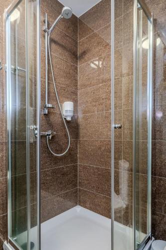 a bathroom with a shower with a glass door at Gamtos Perlas in Karklė