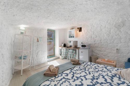 a white room with a bed and a kitchen at Cueva Sol in Fasnia