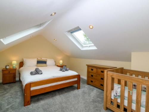 a bedroom with a bed and a skylight at 5 Ger Afon in Pwllheli