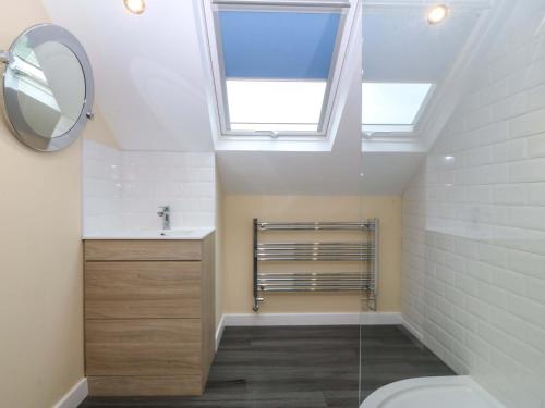 a bathroom with a toilet and a skylight at 5 Ger Afon in Pwllheli