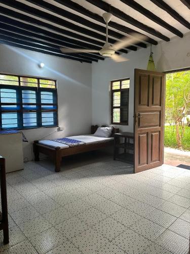 a bedroom with a bed and a door in a room at Warembo beach Nungwi in Nungwi