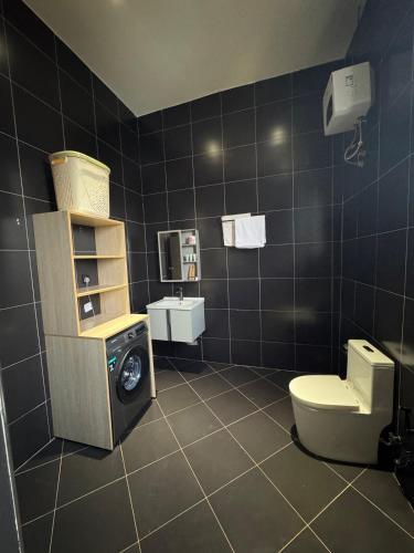 a bathroom with a toilet and a washing machine at Home in Naalya in Kampala