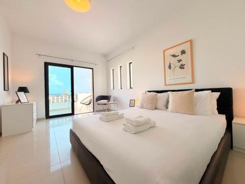 a large white bedroom with a large bed with white sheets at Ultimate Group Getaway Near St Julian's & Seafront in San Ġwann