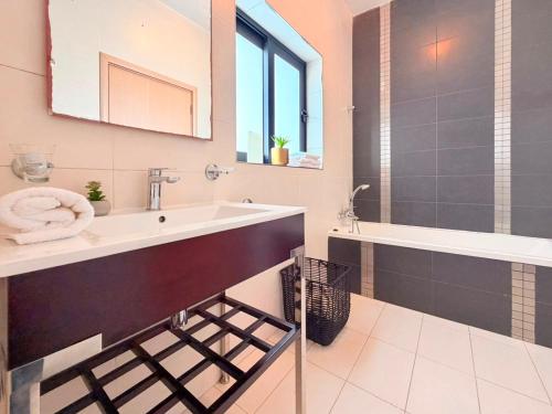 a bathroom with a sink and a bath tub at Ultimate Group Getaway Near St Julian's & Seafront in San Ġwann