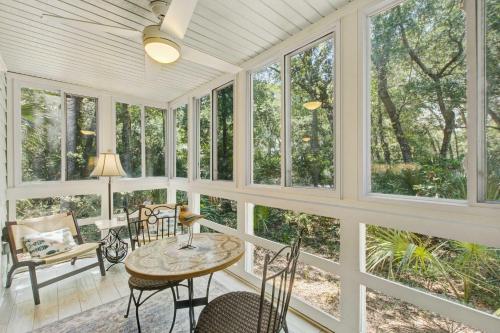 a room with windows and a table and chairs at Seascape 3522 in Kiawah Island