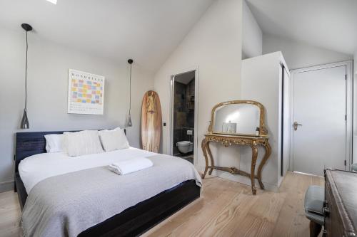 ein Schlafzimmer mit einem großen Bett und einem Spiegel in der Unterkunft Beach House in Croyde