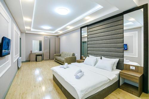 a bedroom with a large bed and a couch at Bea Paradise 112 in Baku