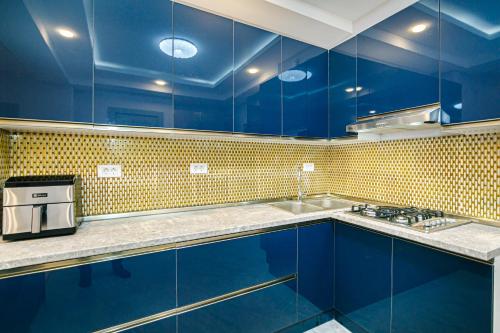 a blue kitchen with blue cabinets and a sink at Bea Paradise 112 in Baku