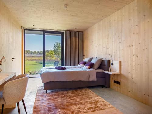 a bedroom with a large bed and a large window at Villa WOOD in Elsendorp