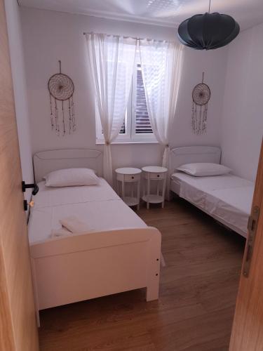 a bedroom with two beds and a window at Ema & Jakov in Sreser