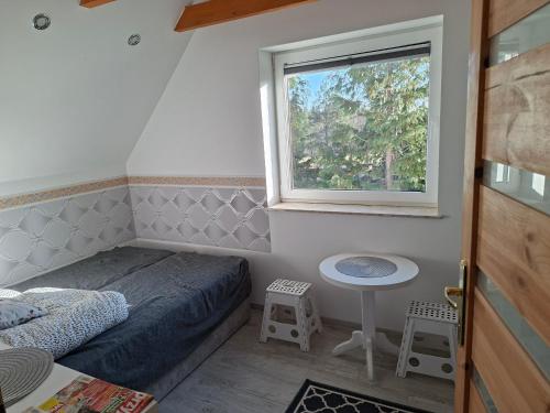 a small bedroom with a bed and a window at Dom Trakt Słupski Sulęczyno in Sulęczyno