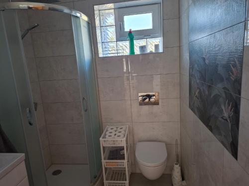 a small bathroom with a toilet and a window at Dom Trakt Słupski Sulęczyno in Sulęczyno